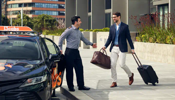 13cabs driver helping passenger with luggage