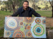 Luke Penrith showcasing his artwork in a bushland clearing