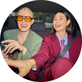 two women in back of car dressed for business